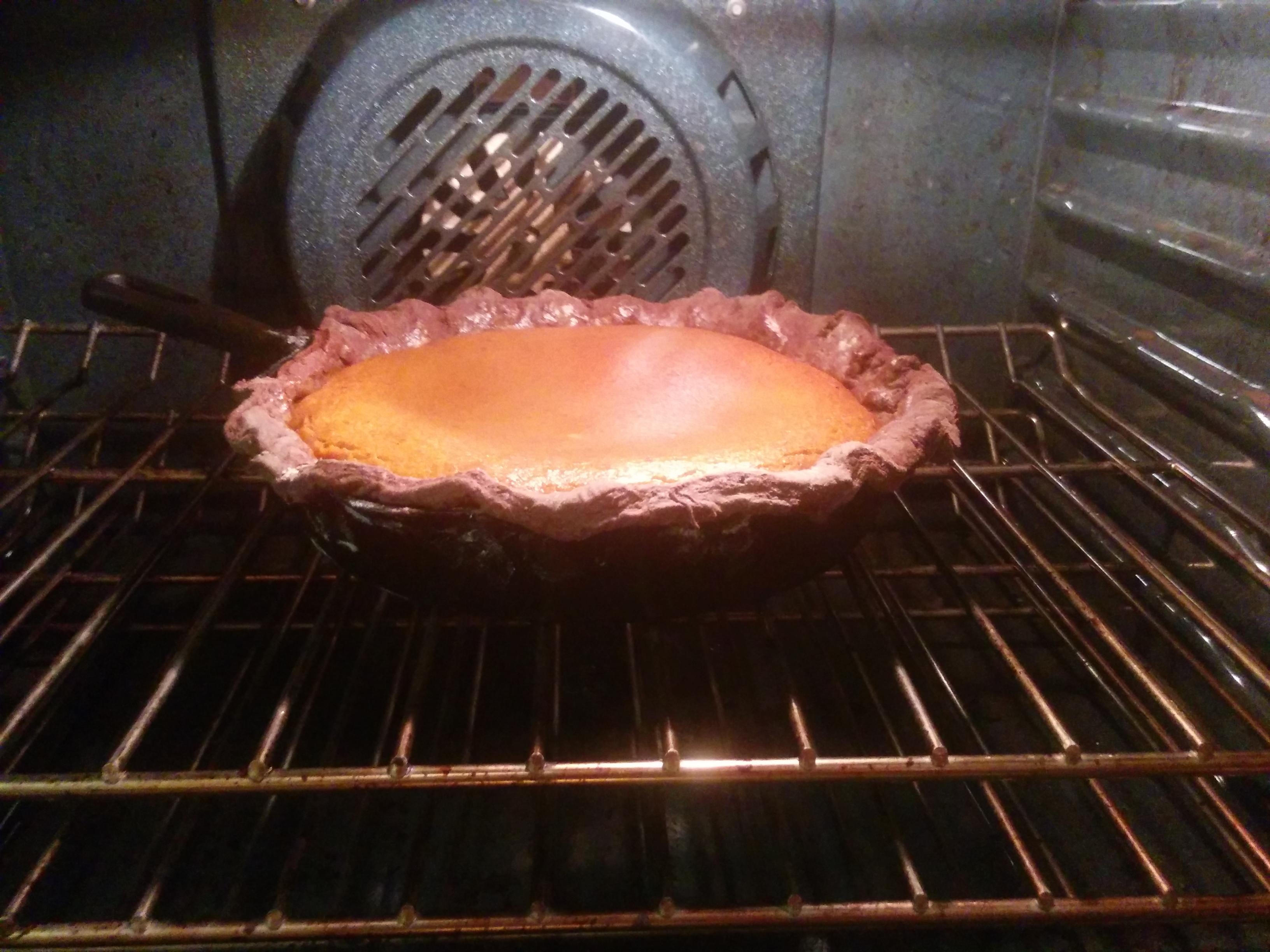 Pumpkin pie in the over in a cast iron pan