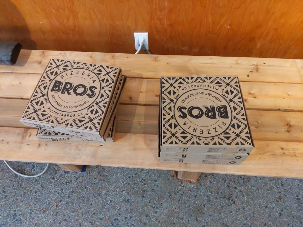 Pizza boxes on a wooden bench
